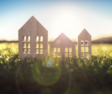 Ecological wood model house in empty field at sunset