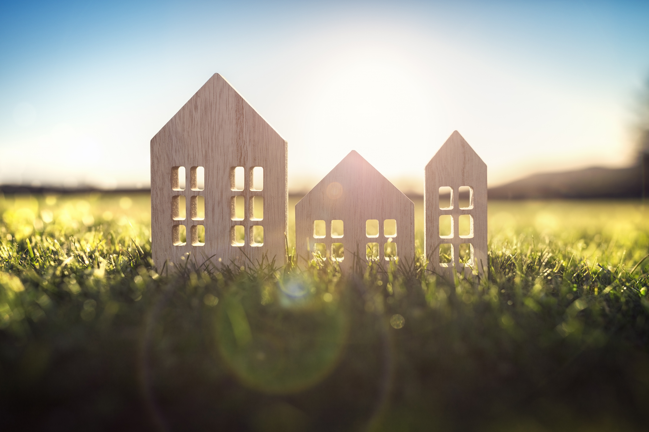 Ecological wood model house in empty field at sunset Ecological wood model house in empty field at sunset