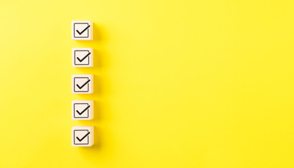 Checklist concept. Correct sign tick check mark on wooden block with copy space for the checklist on yellow background. Business survey questionnaire, Exam test process, filling digital form online,