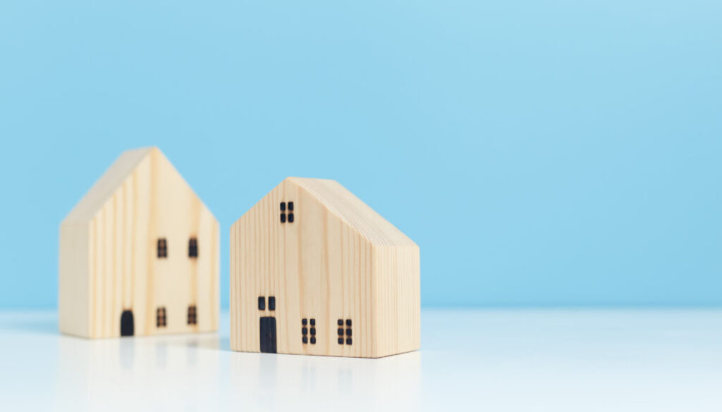 Wooden house model blue background, property business financial success. real estate investment concept.