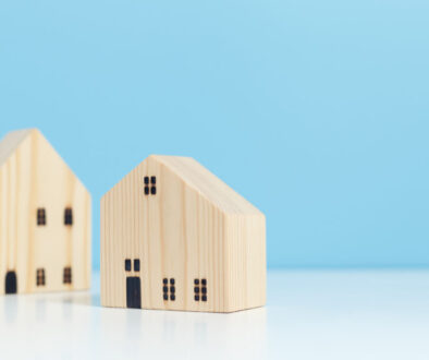 Wooden house model blue background, property business financial success. real estate investment concept.