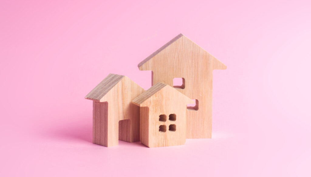 Three houses on a pink background. Buying and selling of real estate, construction. Apartments and apartments. City, settlement. Minimalism. for presentations. real estate market.