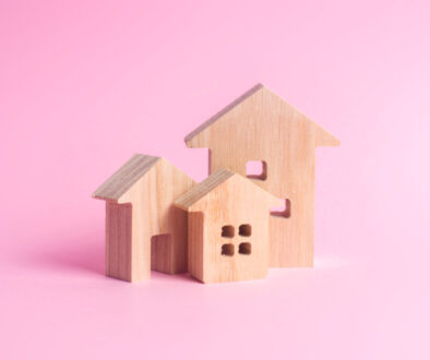 Three houses on a pink background. Buying and selling of real estate, construction. Apartments and apartments. City, settlement. Minimalism. for presentations. real estate market.